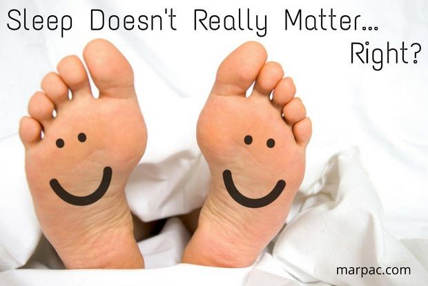 Two bare feet with smiley faces on the soles peeking from white sheets, overlaid text: Sleep Doesn't Really Matter... Right?