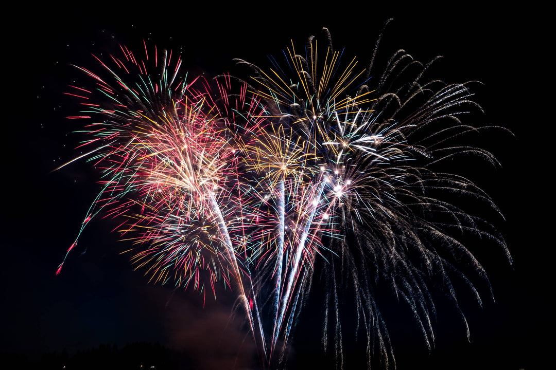 Multi-colored fireworks bursting against a black night sky