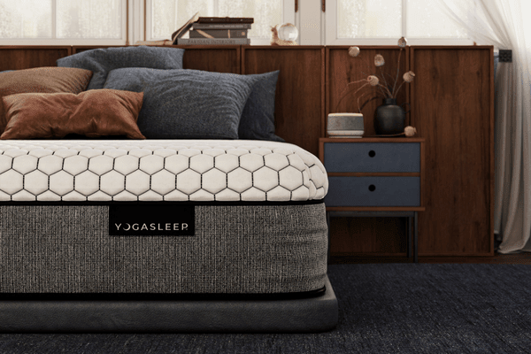 Front view of Yogasleep mattress showcasing hexagonal quilted cover and gray fabric sides in a bedroom