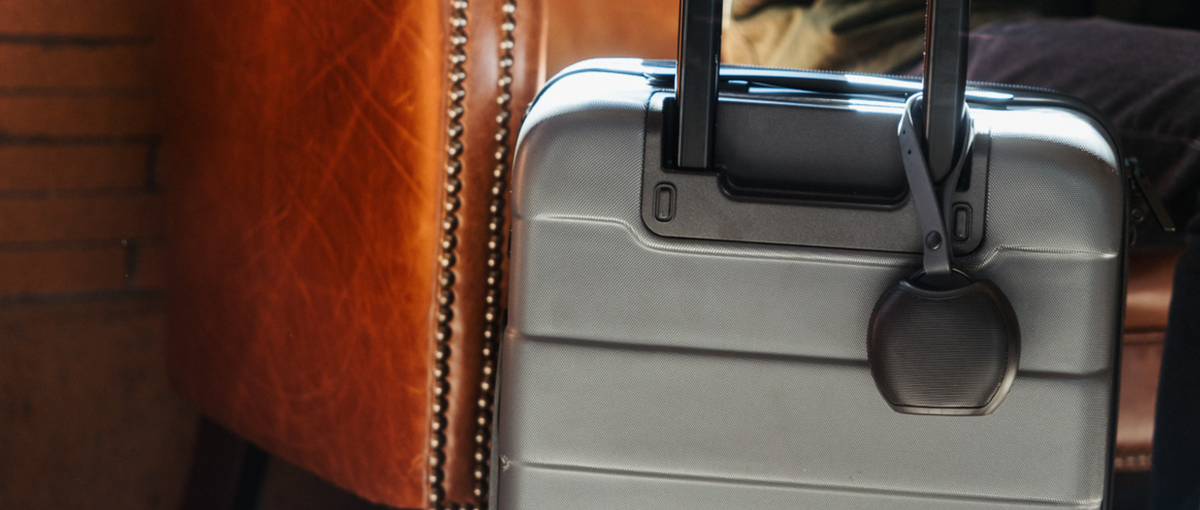 Rohm+ sound machine clipped to a suitcase handle for travel