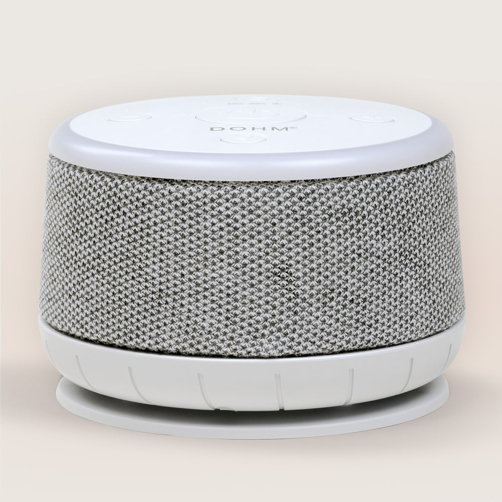 Front angled view of Dohm Nova sound machine showcasing gray knit fabric speaker wrap and white top control panel on pale beige background
