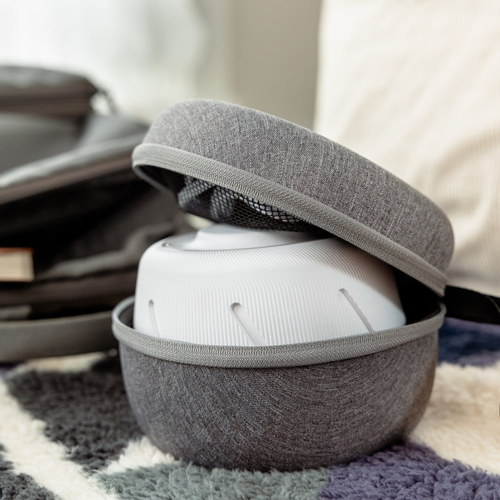 Close up of Dohm Travel Case open showing gray fabric shell and interior mesh pocket with Dohm sound machine inside