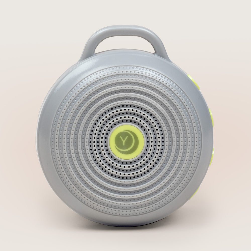 Front view of Hushh portable sound machine with circular speaker grille, top handle, and yellow accent buttons
