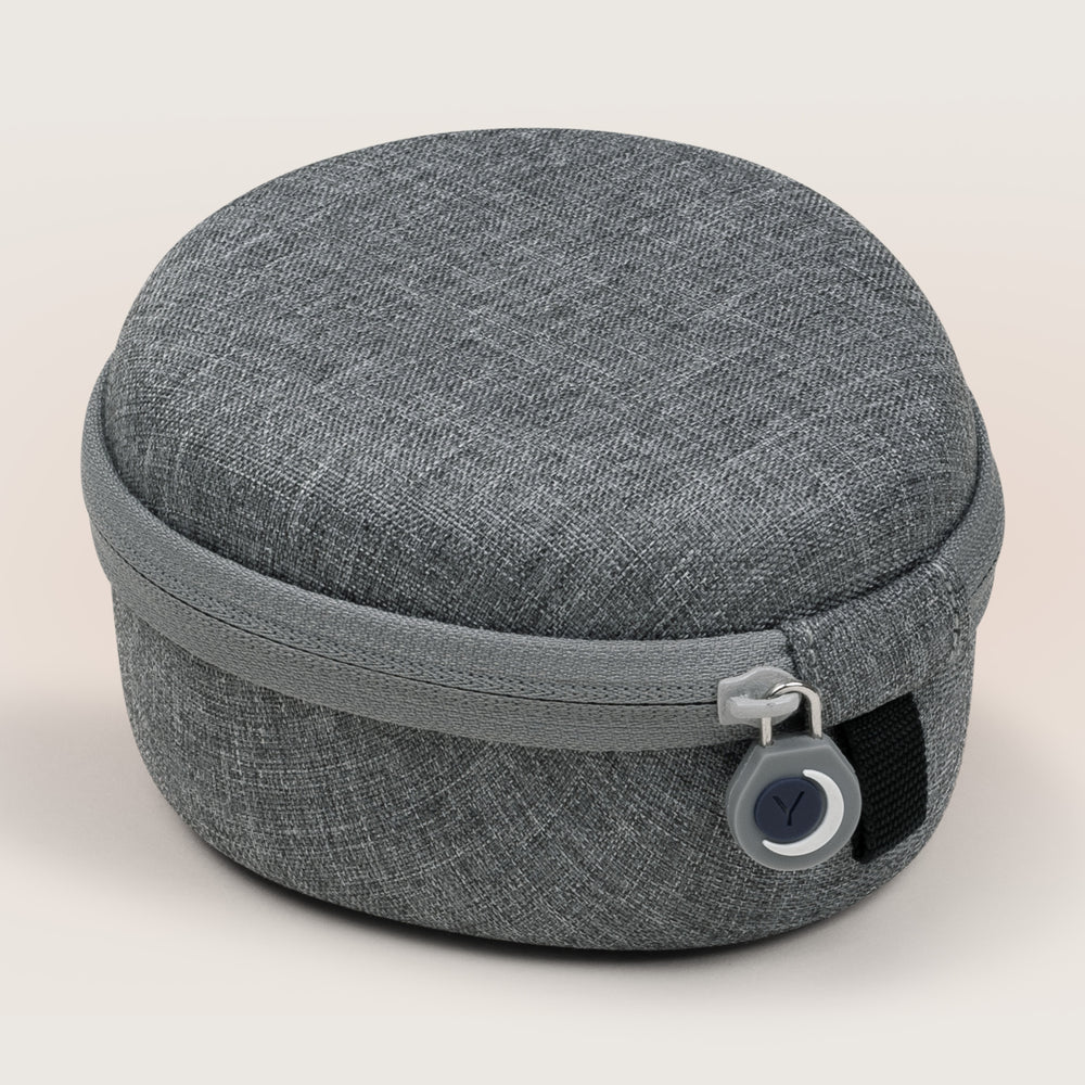 Front view of round gray travel case for Hushh and Rohm sound machines showing zipper pull and textured fabric on a light background