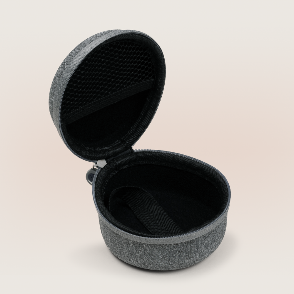 Angled top-down view of open Hushh travel case showing mesh lid pocket and interior strap on beige background
