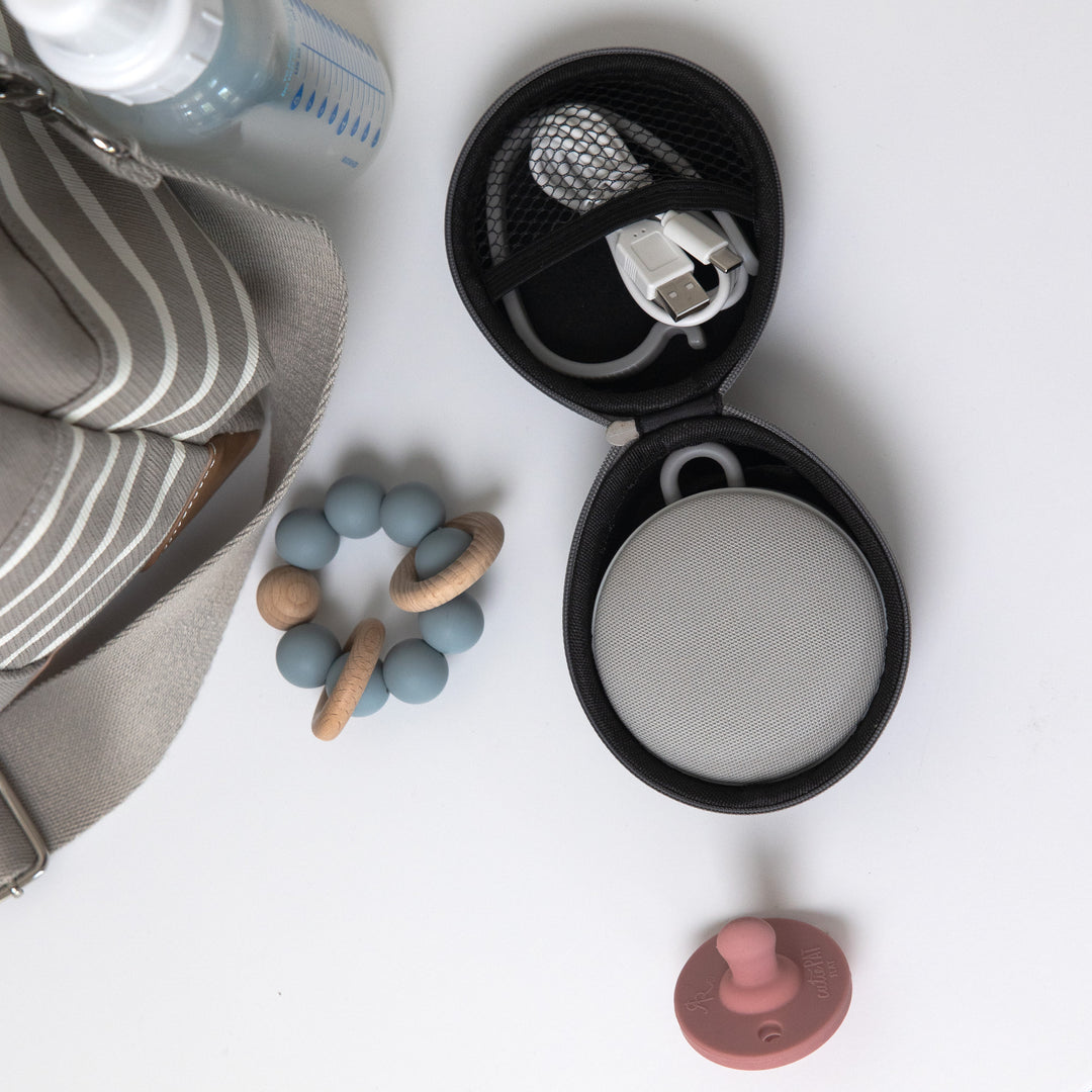 Top-down view of travel case for Hushh and Rohm showcasing open case with sound machine and USB cable on white background