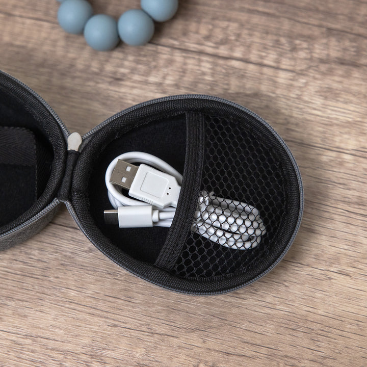 Top-down view of gray travel case open showing mesh pocket with coiled USB cable on wood surface