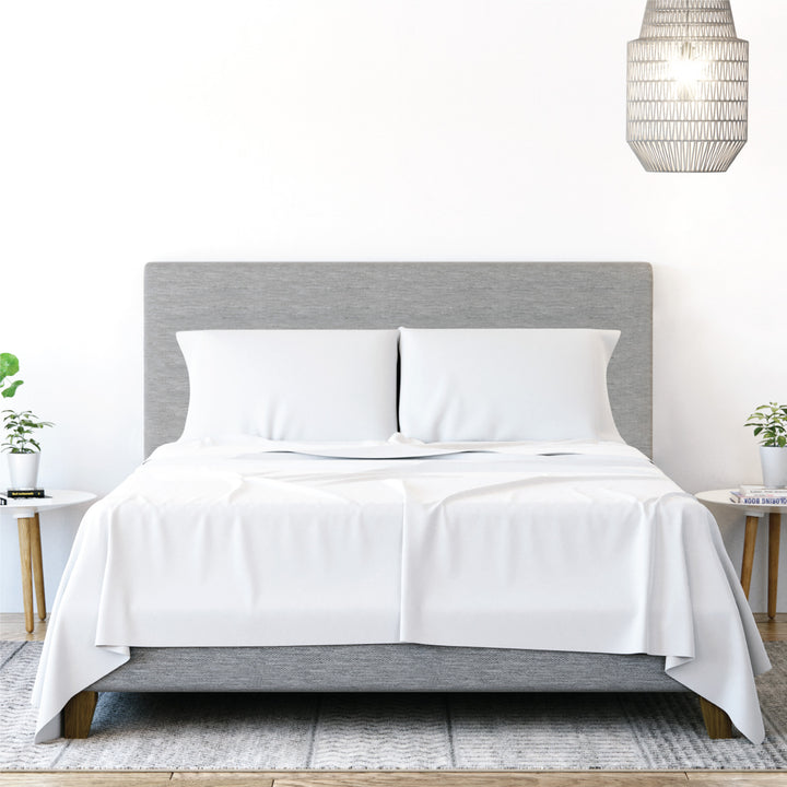 Front view of Yogabed Essential Sleep Bundle showcasing white sheets and pillows with a bright bedroom background