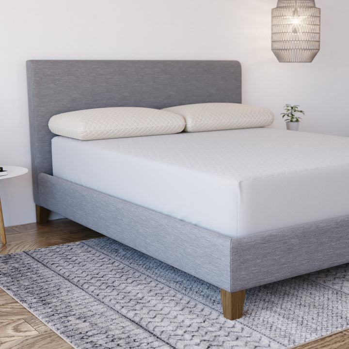 Three-quarter view of Yogabed Ultra Cool Mattress Protector showcasing a white fitted cover on a bed in a bedroom